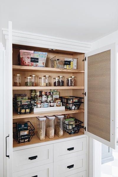 White organized pantry filled with food